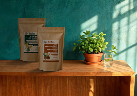 SatRas mustard cake fertiliser and plant growth promoter kraft pouches beside a pot of mint and rooted mint cuttings in a glass of water