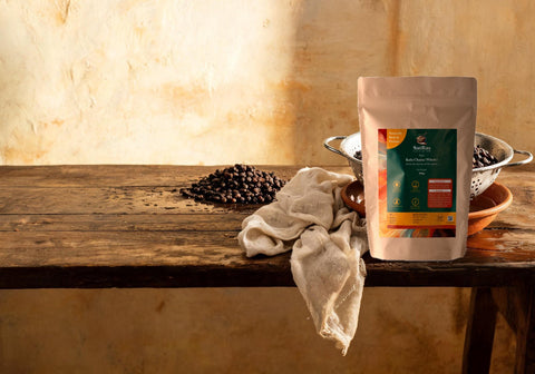 SatRas Desi Kala Chana pouch beside a steel colander of soaked black chana draining over a clay bowl with a damp muslin cloth