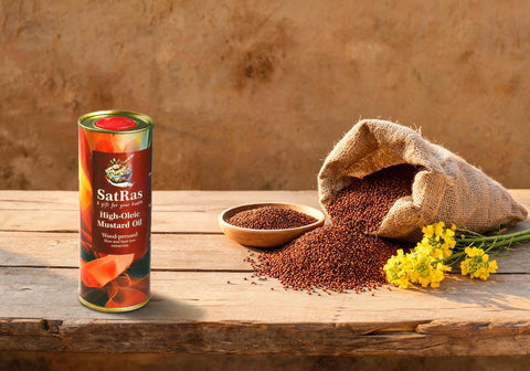 SatRas wood-pressed high oleic mustard oil tin beside a jute sack of Raya Hisar 1706 mustard seeds and yellow mustard blossom