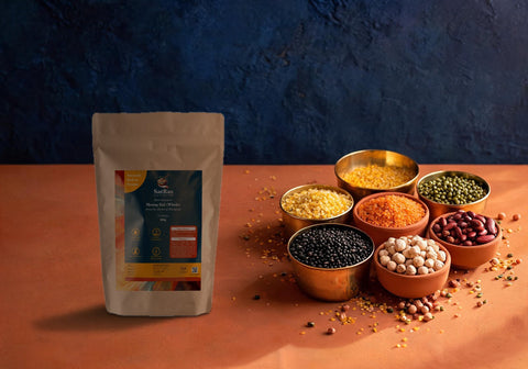 SatRas whole green moong dal pouch beside brass and clay katoris of different Indian dals and pulses